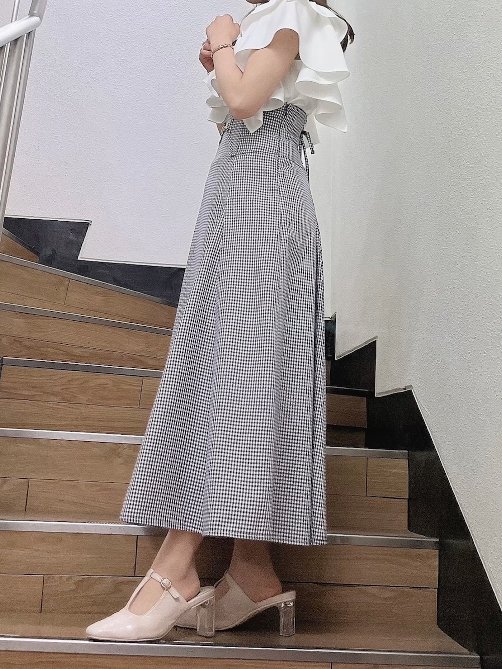 ホワイト系のシャツ/ブラウス、ブラック系のスカート、ホワイト系のパンプスを着用したレディースの夏コーディネートの2枚目の写真