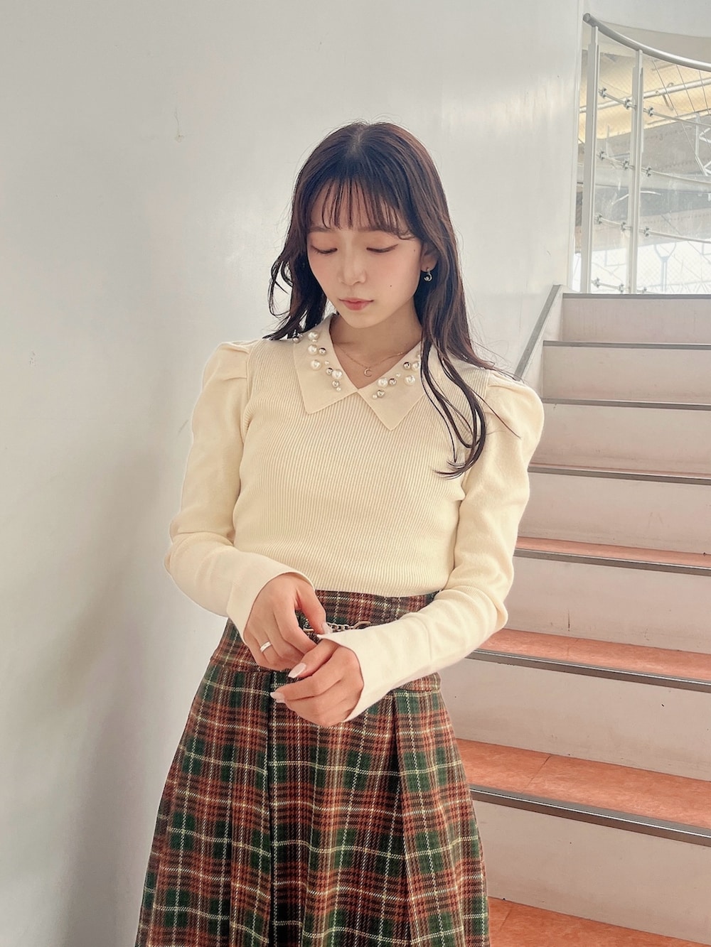 ホワイト系のニット/セーター、グリーン系のスカート、ベージュ系のブーツを着用したレディースの秋コーディネートの6枚目の写真