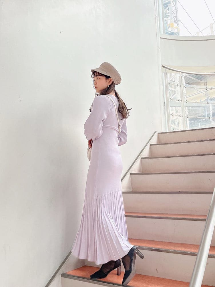 パープル系のワンピース、ブラック系のブーツ、ホワイト系のショルダーバッグを着用したレディースの冬コーディネートの3枚目の写真