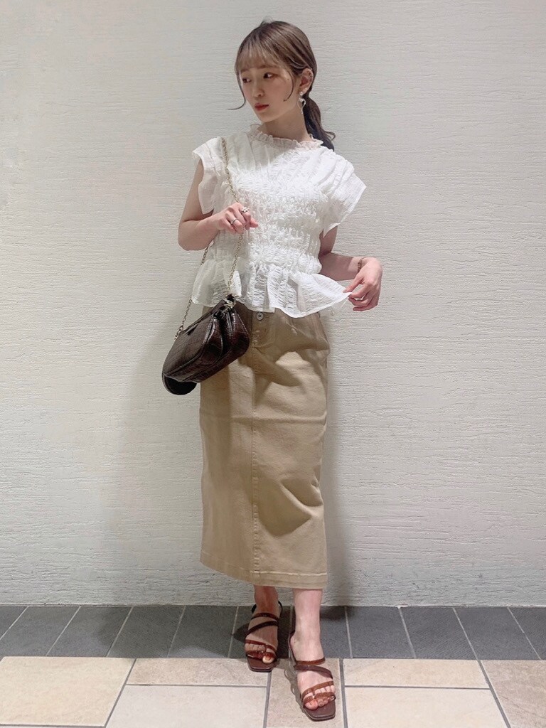 ホワイト系のシャツ/ブラウス、ベージュ系のスカート、ブラウン系のサンダルを着用したレディースの春コーディネートの2枚目の写真