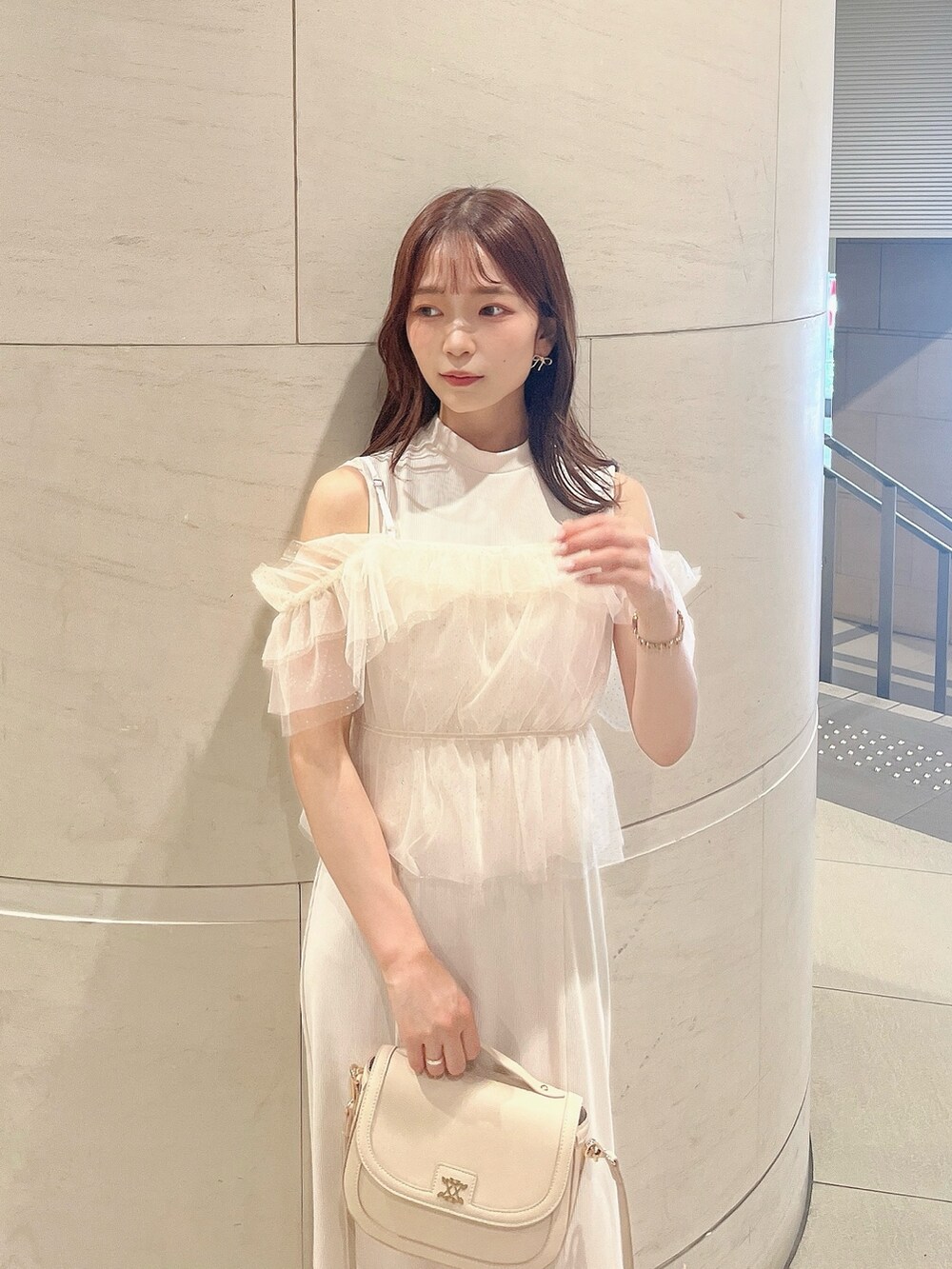 ホワイト系のワンピース、ホワイト系のパンプス、ホワイト系のハンドバッグを着用したレディースの夏コーディネートの10枚目の写真