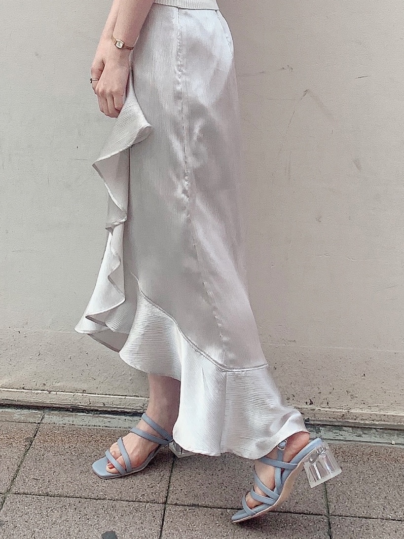 グレー系のスカート、ブルー系のサンダル、ホワイト系のニット/セーターを着用したレディースの春コーディネートの6枚目の写真