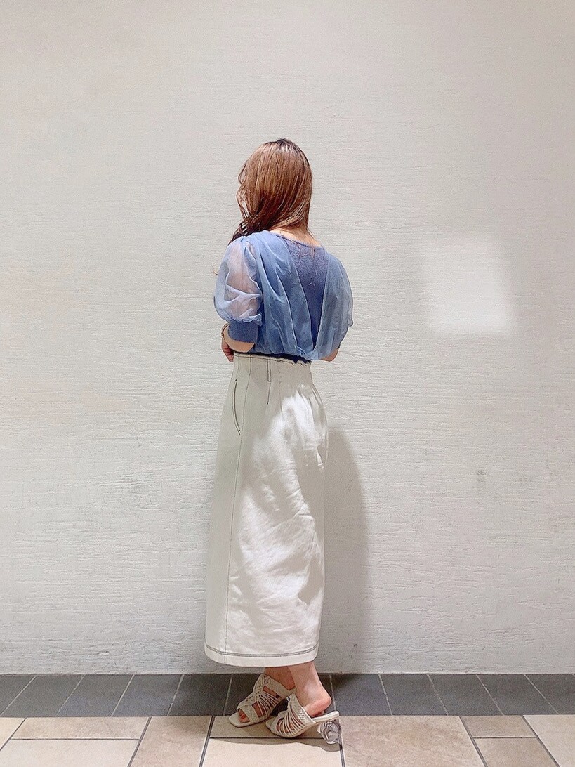 ホワイト系のスカート、ホワイト系のサンダル、ブルー系のニット/セーターを着用したレディースの春コーディネートの2枚目の写真