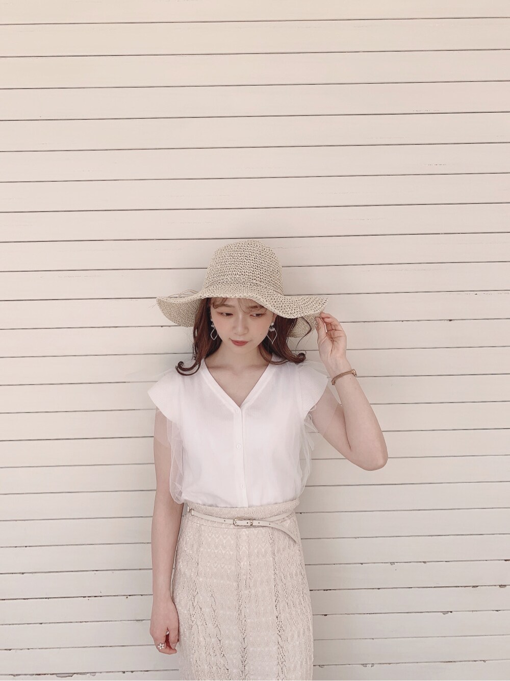 ホワイト系のスカート、ブラウン系のパンプス、ホワイト系のニット/セーターを着用したレディースの春コーディネートの6枚目の写真