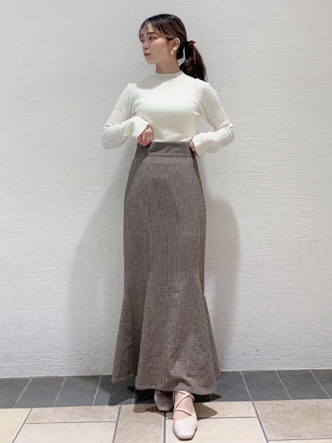 ホワイト系のパンプス、ブラウン系のスカート、ホワイト系のニット/セーターを着用したレディースの夏コーディネートの2枚目の写真