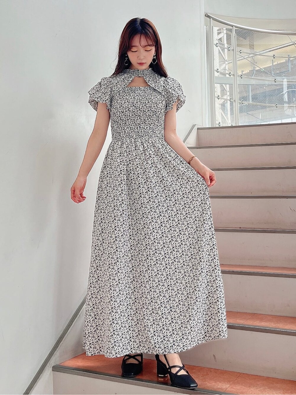 ホワイト系のワンピース、ブラック系のパンプスを着用したレディースの夏コーディネートの3枚目の写真