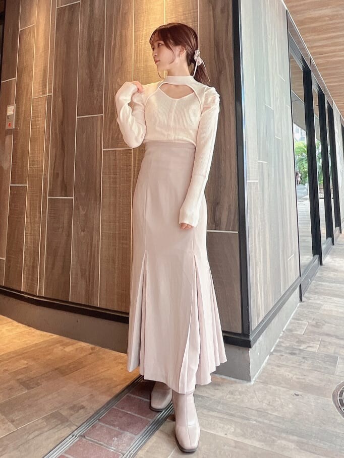 ベージュ系のブーツ、ベージュ系のスカート、ホワイト系のニット/セーターを着用したレディースの秋コーディネートの2枚目の写真