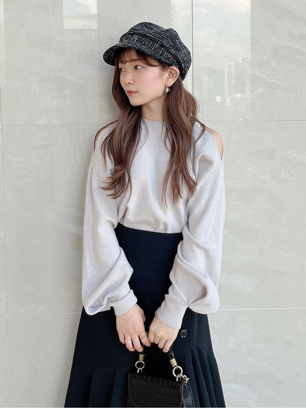 グレー系のニット/セーター、ブラック系のスカート、ブラック系のパンプスを着用したレディースの夏コーディネートの5枚目の写真