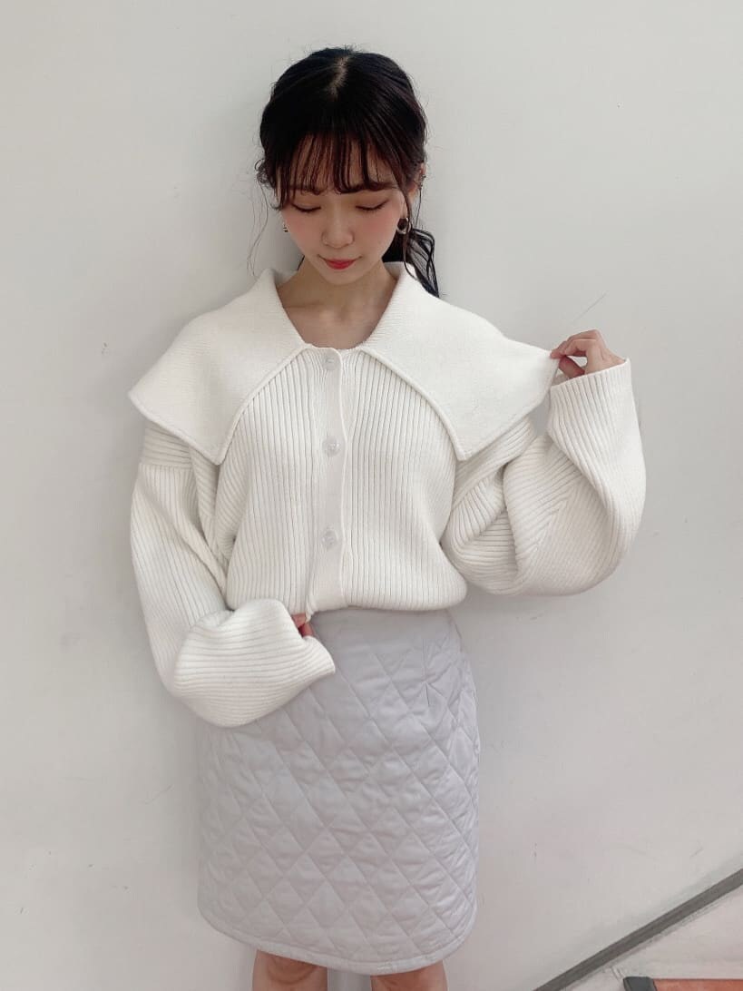 グレー系のスカート、グレー系のブーツ、ホワイト系のニット/セーターを着用したレディースの秋コーディネートの5枚目の写真