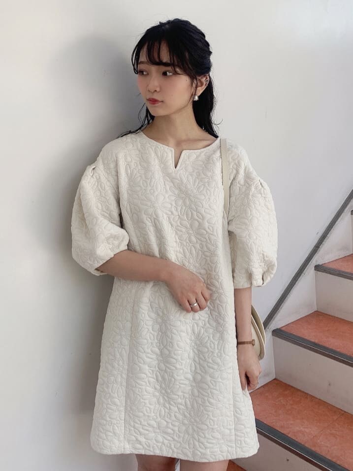 ホワイト系のチュニック、ベージュ系のショルダーバッグ、ベージュ系のブーツを着用したレディースの秋コーディネートの6枚目の写真