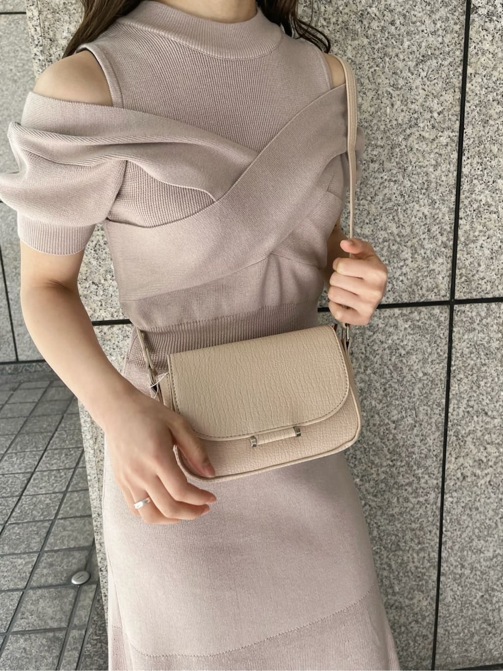 ピンク系のワンピース、ブラック系のブーツ、ホワイト系のショルダーバッグを着用したレディースの冬コーディネートの8枚目の写真