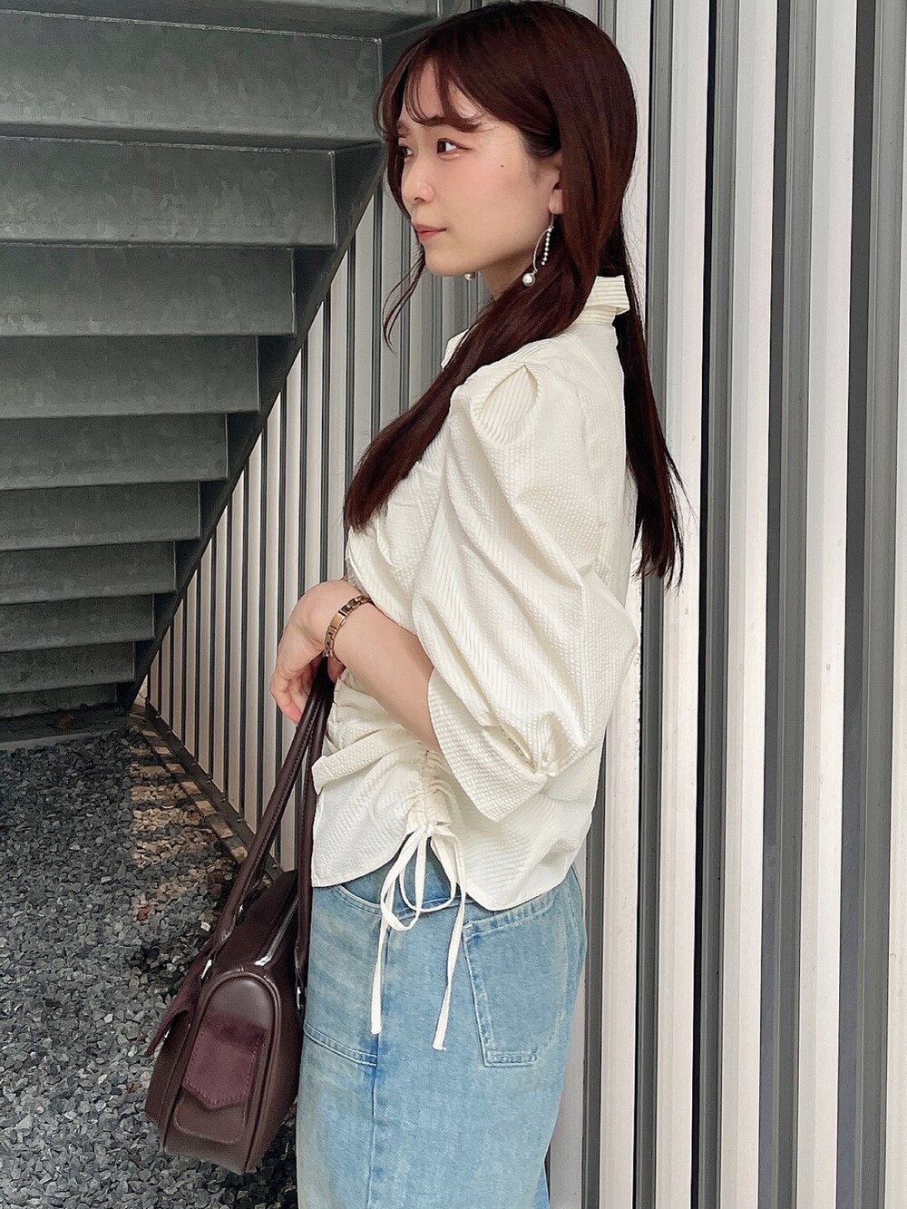 イエロー系のシャツ/ブラウス、ブルー系のデニムパンツ、ブラウン系のボストンバッグを着用したレディースの夏コーディネートの6枚目の写真