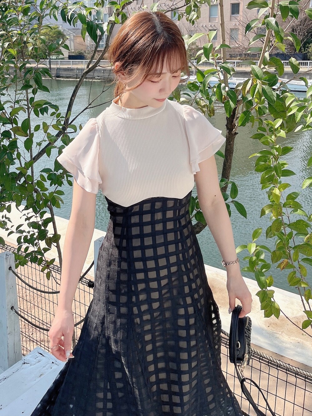 ホワイト系のワンピース、ブラック系のパンプスを着用したレディースの春コーディネートの8枚目の写真