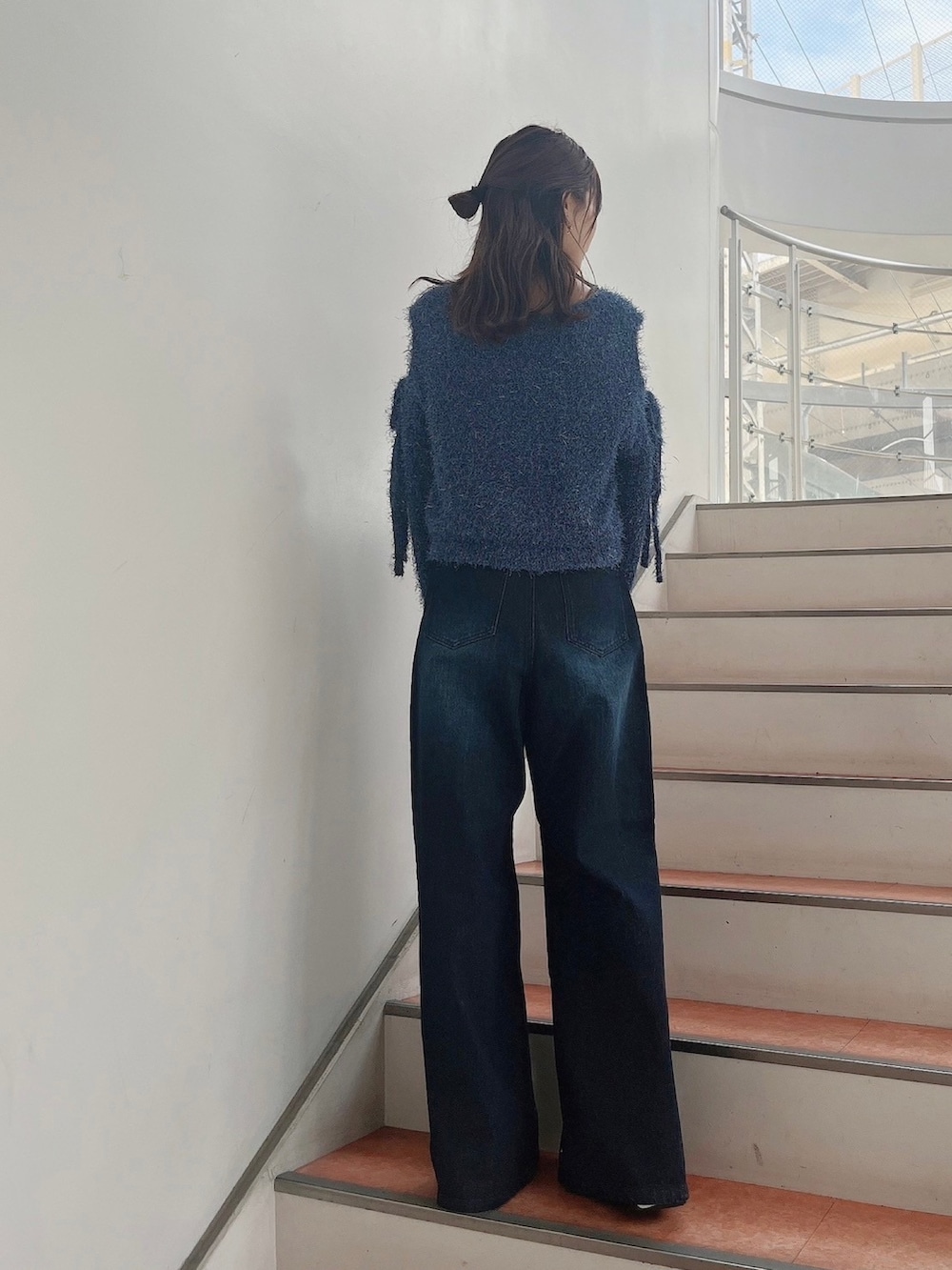 ブルー系のニット/セーター、ブルー系のデニムパンツ、ホワイト系のサンダルを着用したレディースの夏コーディネートの4枚目の写真