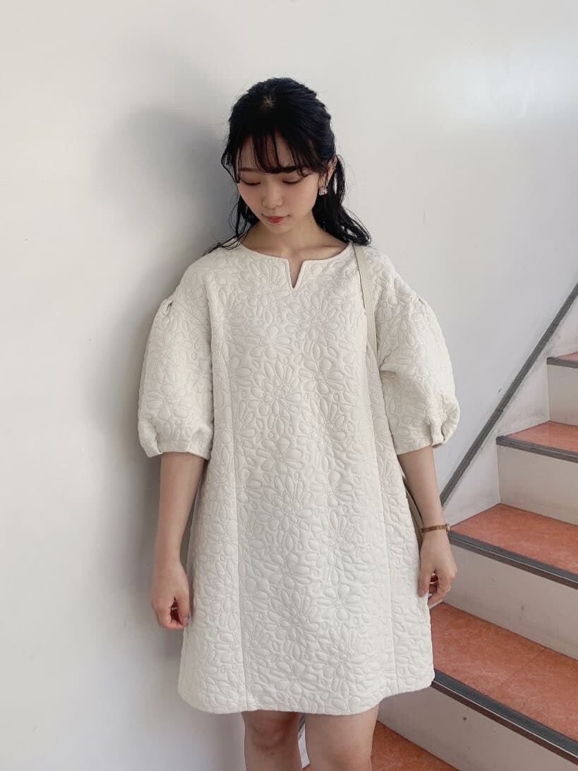 ホワイト系のチュニック、ベージュ系のショルダーバッグ、ベージュ系のブーツを着用したレディースの秋コーディネートの5枚目の写真