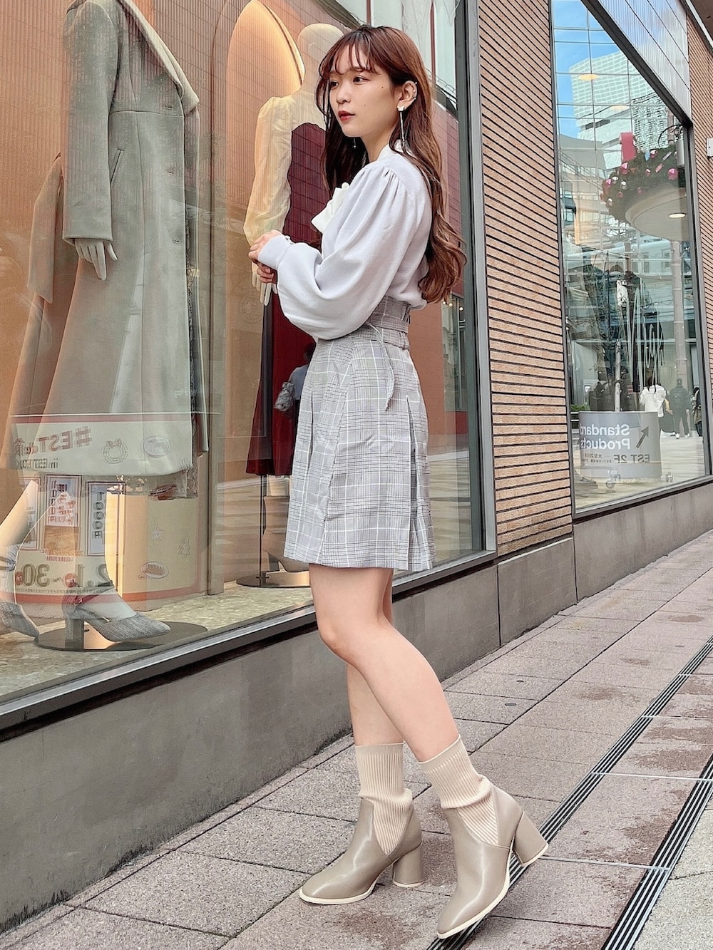 グレー系のニット/セーター、グレー系のスカート、ベージュ系のブーツを着用したレディースの冬コーディネートの5枚目の写真