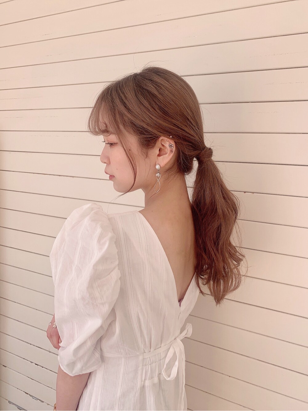 ホワイト系のワンピース、ベージュ系のサンダル、ブラウン系のハットを着用したレディースの春コーディネートの7枚目の写真