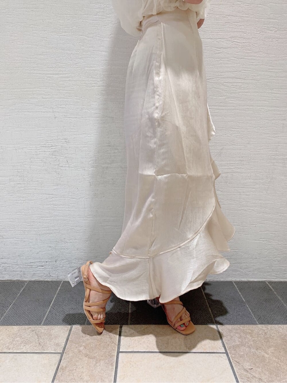 ホワイト系のスカート、ホワイト系のニット/セーター、オレンジ系のサンダルを着用したレディースの夏コーディネートの10枚目の写真