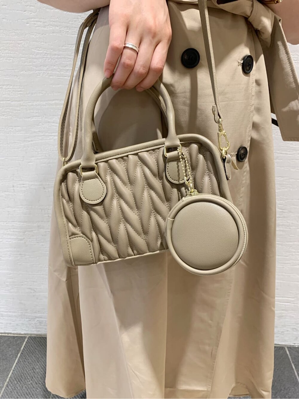 ベージュ系のワンピース、ベージュ系のブーツ、ホワイト系のニット/セーターを着用したレディースの秋コーディネートの9枚目の写真