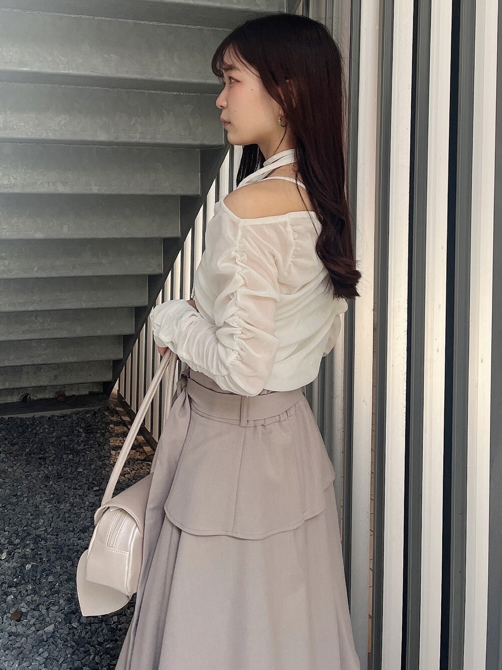 ベージュ系のハンドバッグ、ベージュ系のブーツ、ホワイト系のTシャツ/カットソーを着用したレディースの春コーディネートの5枚目の写真