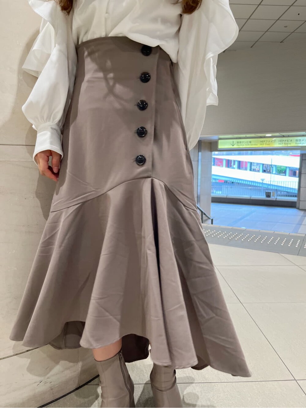 ベージュ系のブーツ、ベージュ系のスカート、ホワイト系のシャツ/ブラウスを着用したレディースの秋コーディネートの9枚目の写真