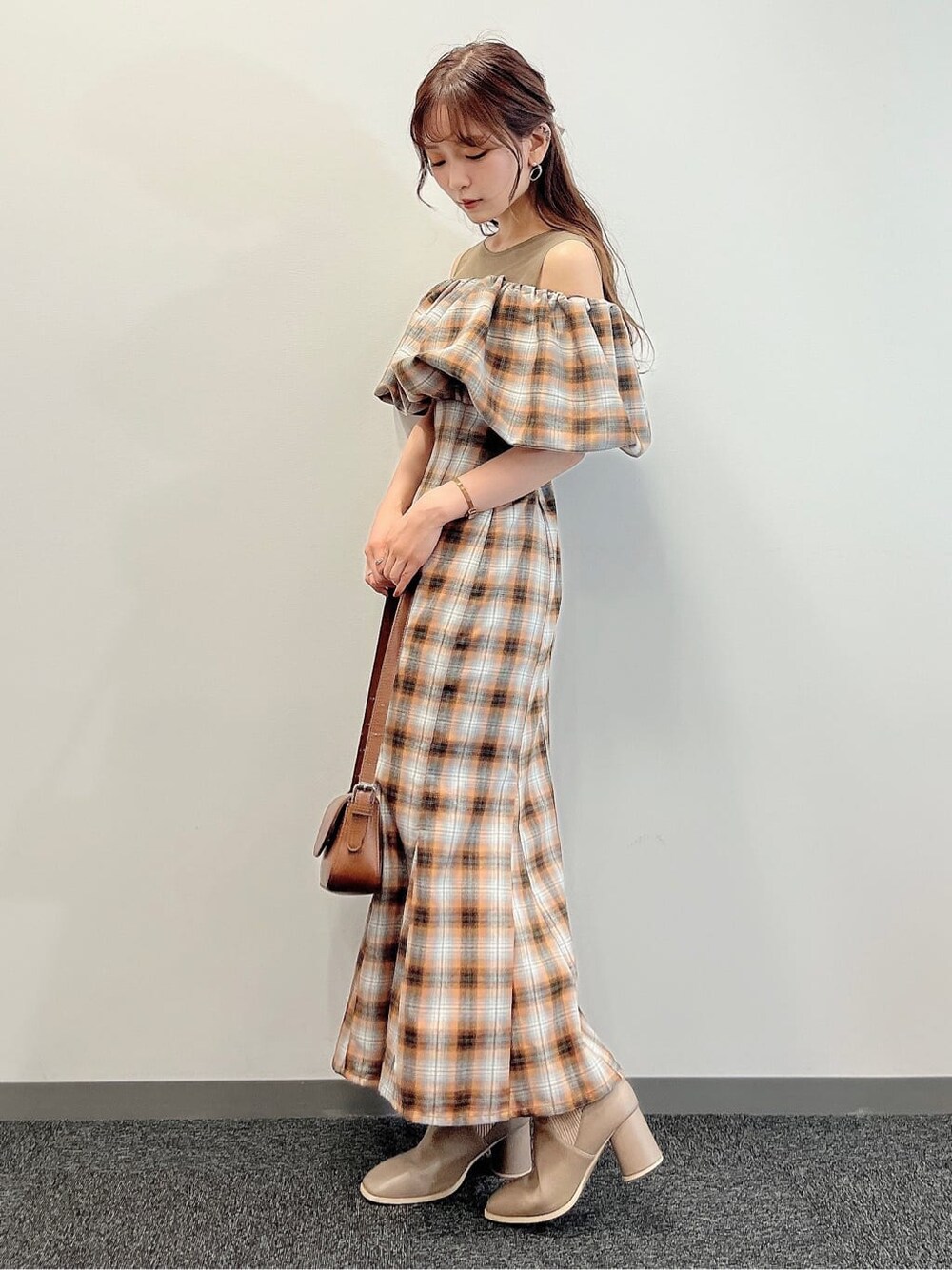 オレンジ系のワンピース、ベージュ系のブーツを着用したレディースの夏コーディネートの4枚目の写真