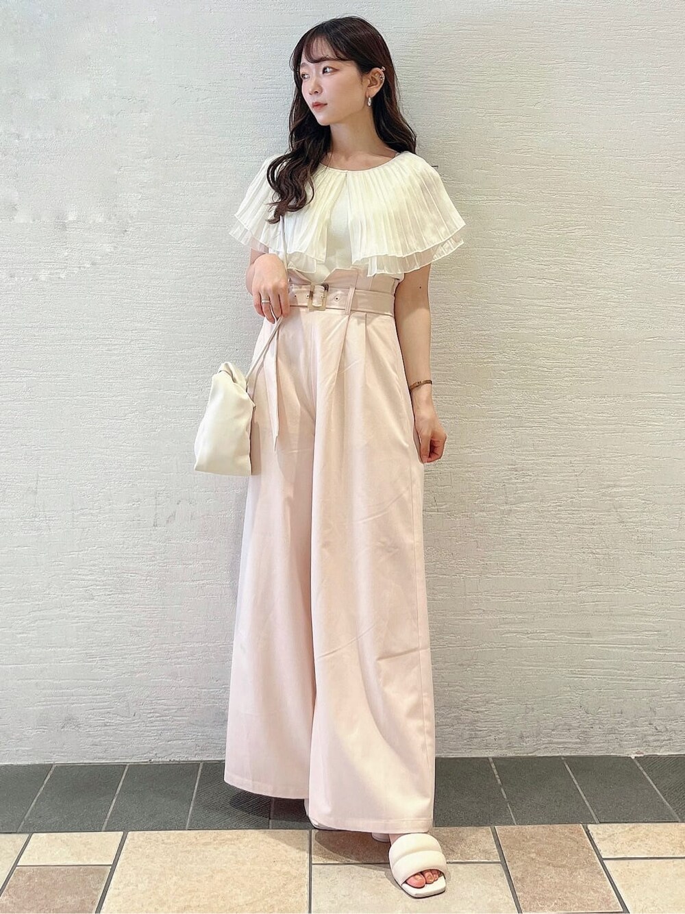 ベージュ系のその他パンツ、ホワイト系のサンダル、ホワイト系のニット/セーターを着用したレディースの夏コーディネートの3枚目の写真