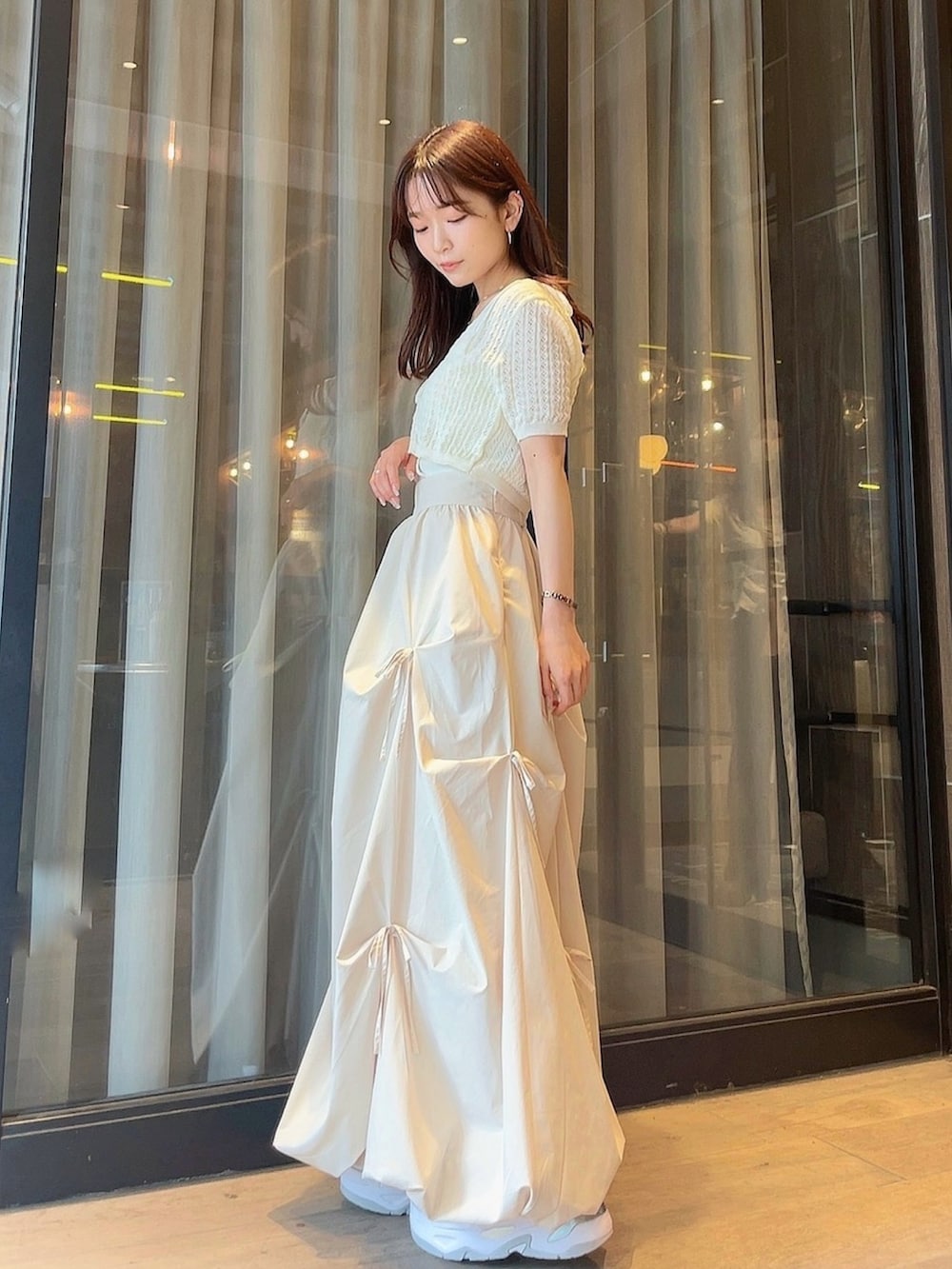 ホワイト系のニット/セーター、ホワイト系のスカートを着用したレディースの夏コーディネートの4枚目の写真