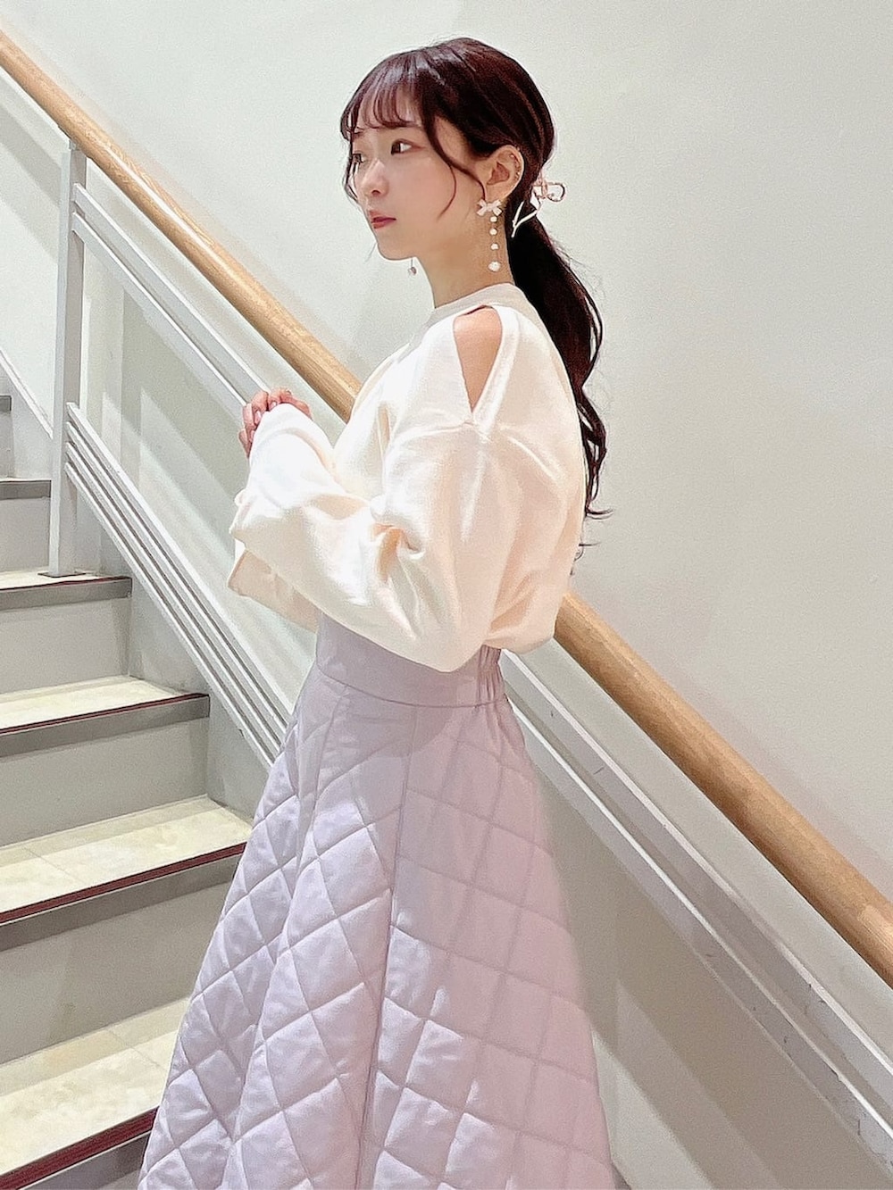 ホワイト系のニット/セーター、ピンク系のスカート、ベージュ系のブーツを着用したレディースの秋コーディネートの4枚目の写真