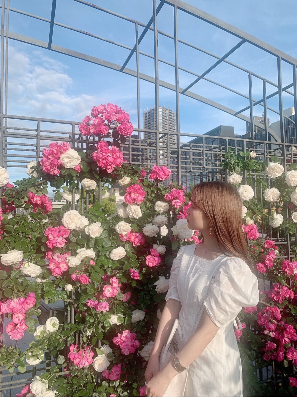 ホワイト系のパンプス、ホワイト系のワンピースを着用したレディースの春コーディネートの3枚目の写真