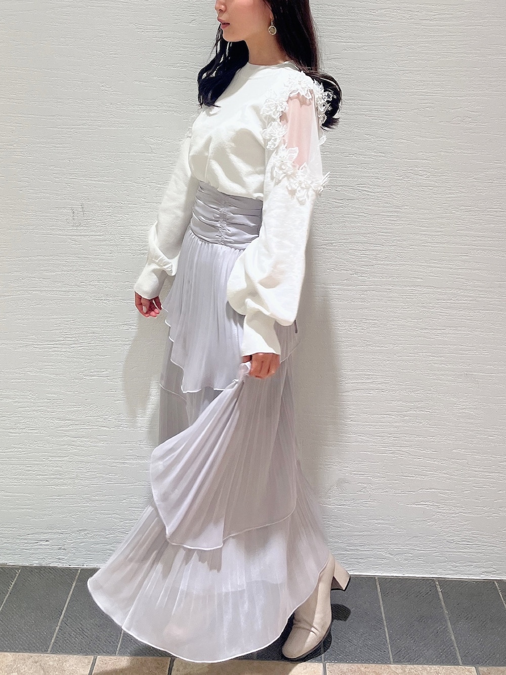 ベージュ系のブーツ、グレー系のスカート、ホワイト系のニット/セーターを着用したレディースの冬コーディネートの3枚目の写真