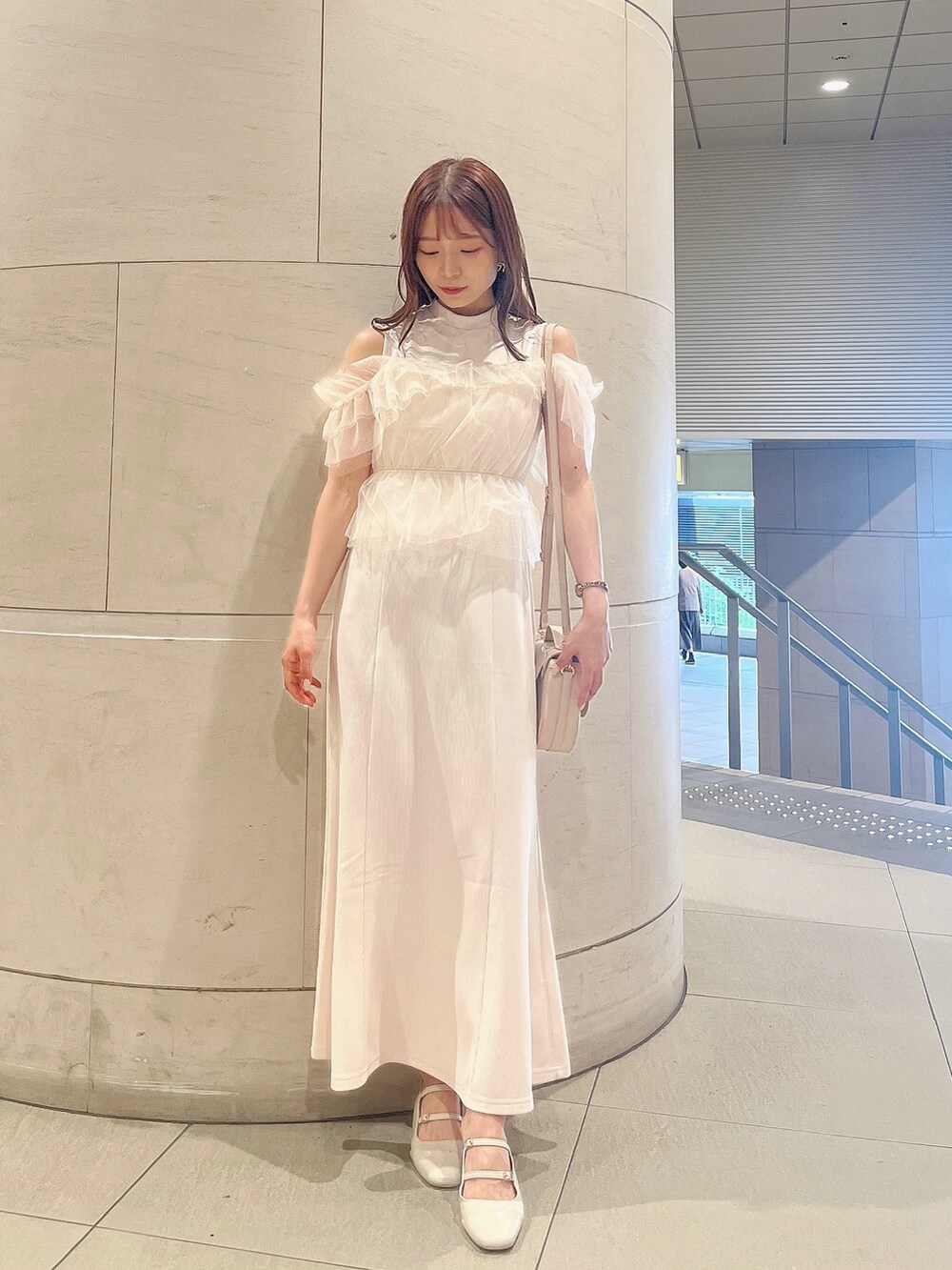 ホワイト系のワンピース、ホワイト系のパンプス、ホワイト系のハンドバッグを着用したレディースの夏コーディネートの5枚目の写真