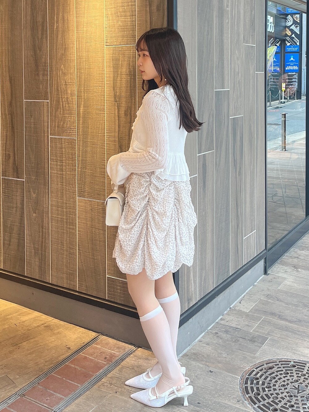 ホワイト系のカーディガン/ボレロ、ピンク系のワンピース、ホワイト系のパンプスを着用したレディースの春コーディネートの2枚目の写真