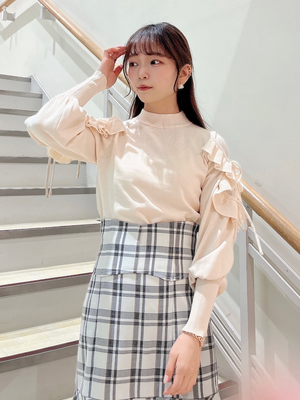 ホワイト系のニット/セーター、ホワイト系のスカート、ベージュ系のブーツを着用したレディースの冬コーディネートの5枚目の写真