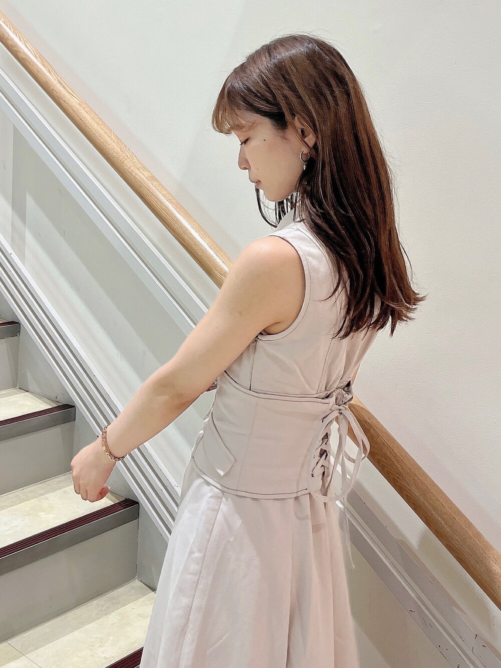 ホワイト系のワンピース、ブラウン系のパンプスを着用したレディースの夏コーディネートの7枚目の写真