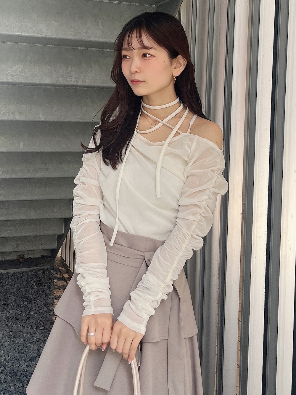 ベージュ系のハンドバッグ、ベージュ系のブーツ、ホワイト系のTシャツ/カットソーを着用したレディースの春コーディネートの8枚目の写真