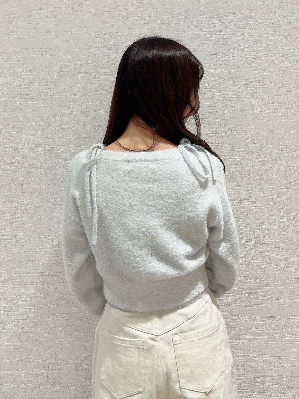 グレー系のキャミソール、グレー系のカーディガン/ボレロ、ホワイト系のデニムパンツを着用したレディースの冬コーディネートの9枚目の写真