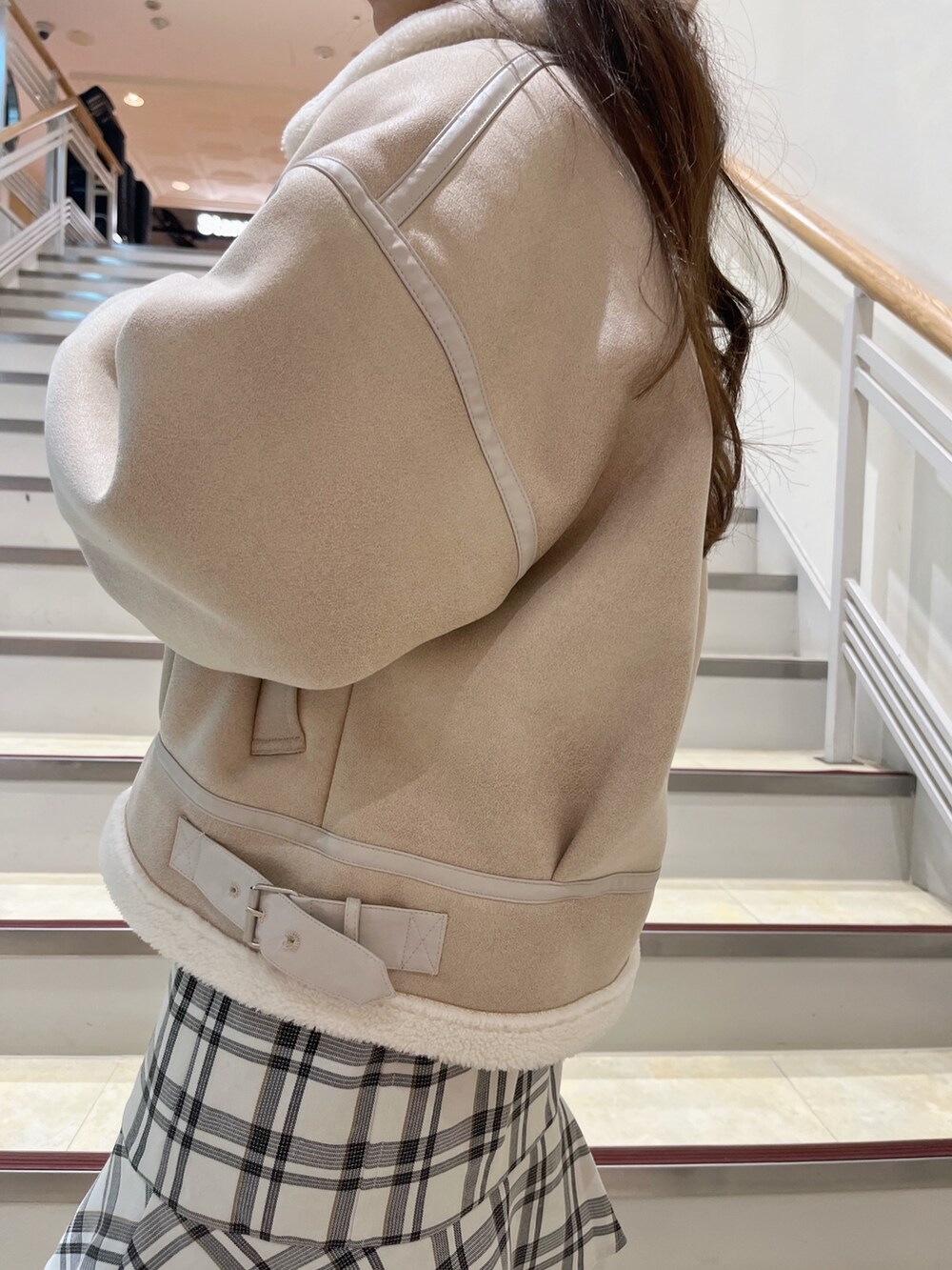 ホワイト系のブルゾン、ホワイト系のスカート、ベージュ系のブーツを着用したレディースの冬コーディネートの10枚目の写真