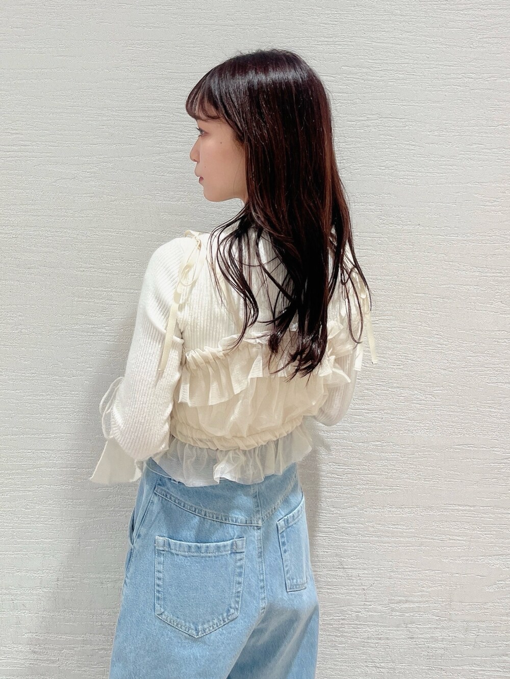 ベージュ系のブーツ、ブルー系のデニムパンツ、ベージュ系のキャミソールを着用したレディースの冬コーディネートの8枚目の写真