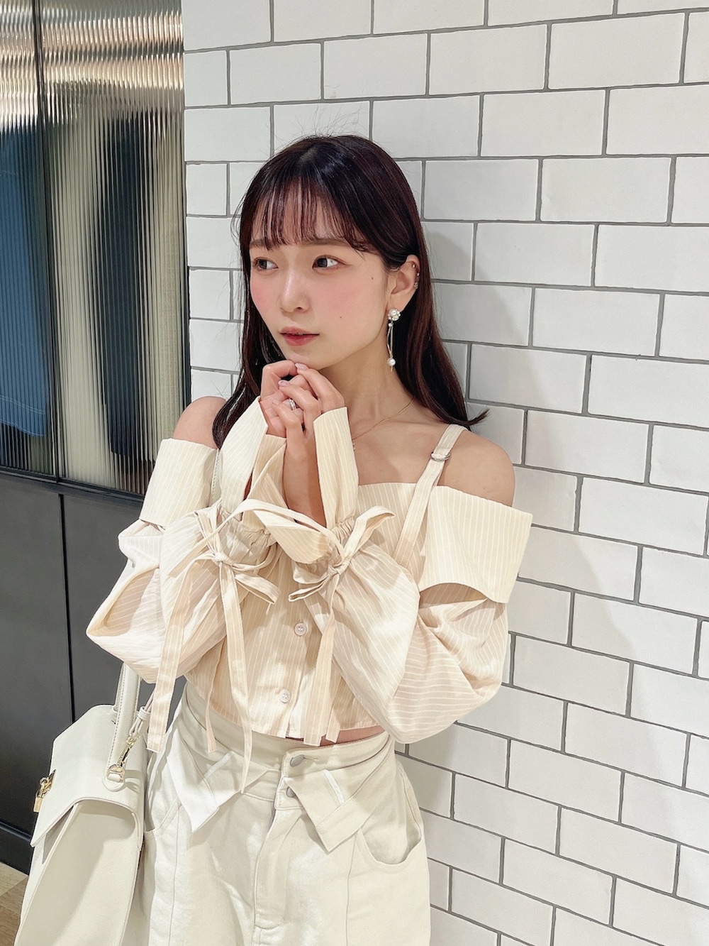 イエロー系のシャツ/ブラウス、ホワイト系のデニムパンツを着用したレディースの春コーディネートの6枚目の写真