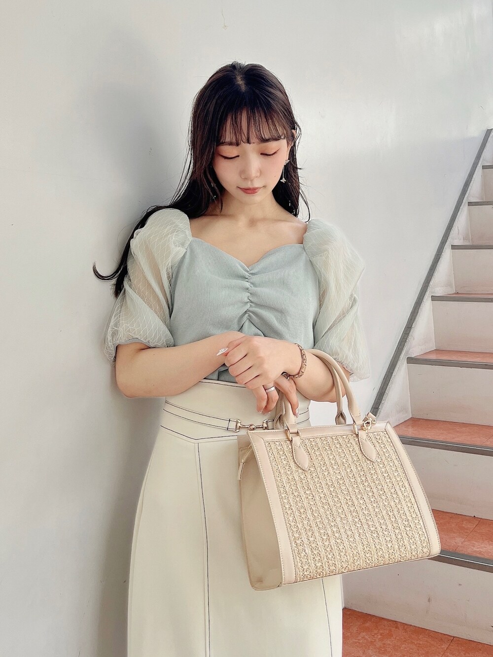 グリーン系のTシャツ/カットソー、ホワイト系のスカート、ホワイト系のサンダルを着用したレディースの春コーディネートの6枚目の写真