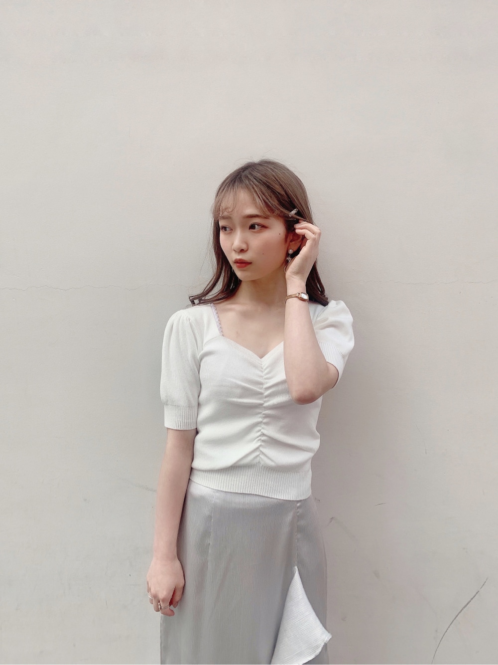 グレー系のスカート、ブルー系のサンダル、ホワイト系のニット/セーターを着用したレディースの春コーディネートの8枚目の写真