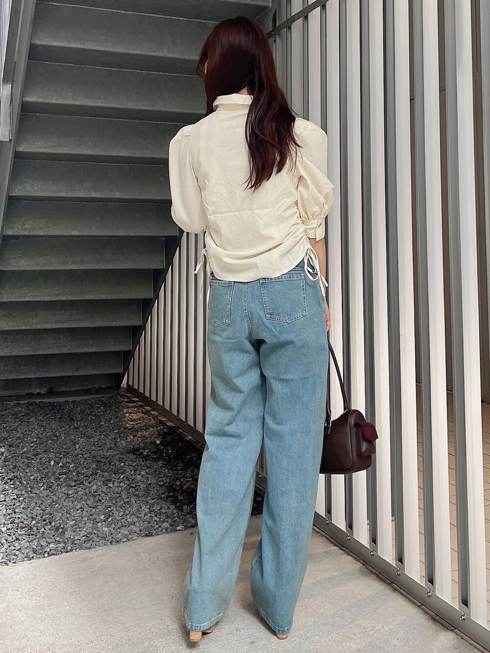 イエロー系のシャツ/ブラウス、ブルー系のデニムパンツ、ブラウン系のボストンバッグを着用したレディースの夏コーディネートの4枚目の写真