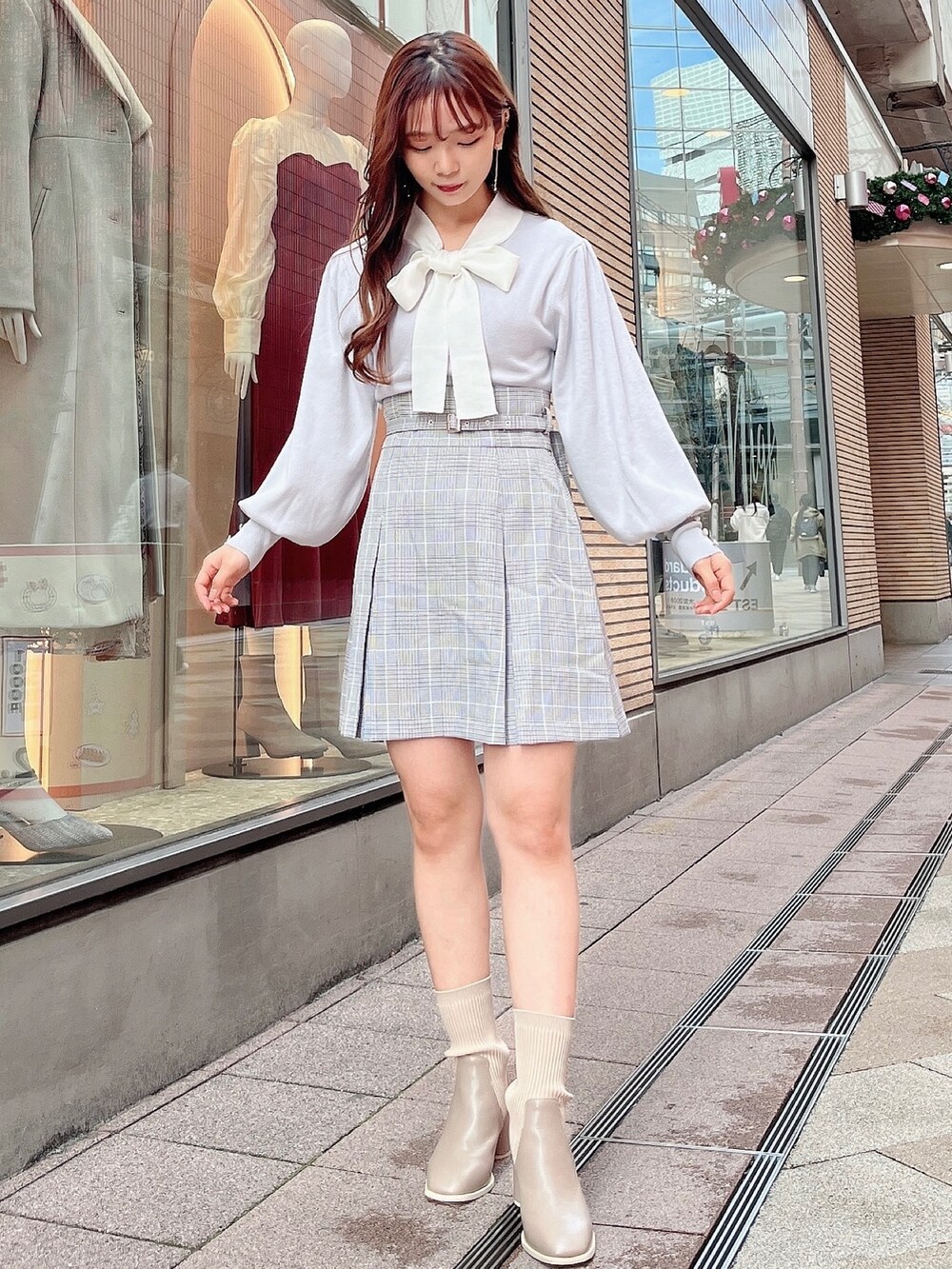 グレー系のニット/セーター、グレー系のスカート、ベージュ系のブーツを着用したレディースの冬コーディネートの4枚目の写真