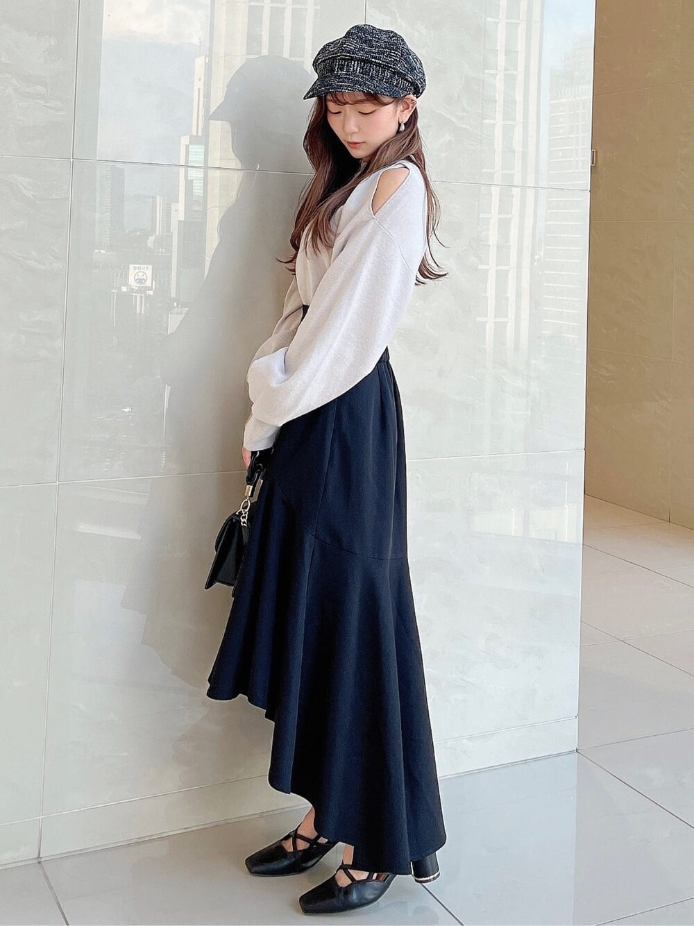 グレー系のニット/セーター、ブラック系のスカート、ブラック系のパンプスを着用したレディースの夏コーディネートの3枚目の写真