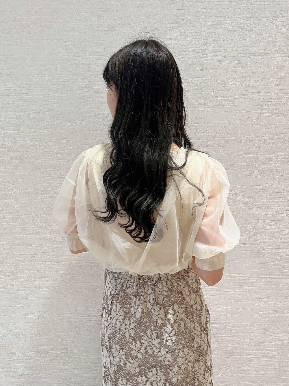 ベージュ系のスカート、ホワイト系のパンプス、ホワイト系のニット/セーターを着用したレディースの春コーディネートの6枚目の写真