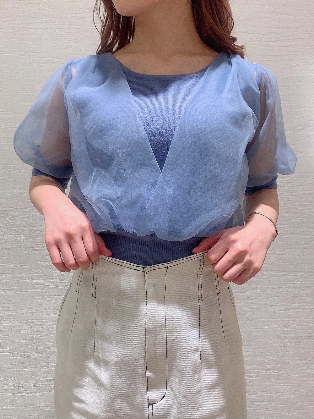 ホワイト系のスカート、ホワイト系のサンダル、ブルー系のニット/セーターを着用したレディースの春コーディネートの6枚目の写真