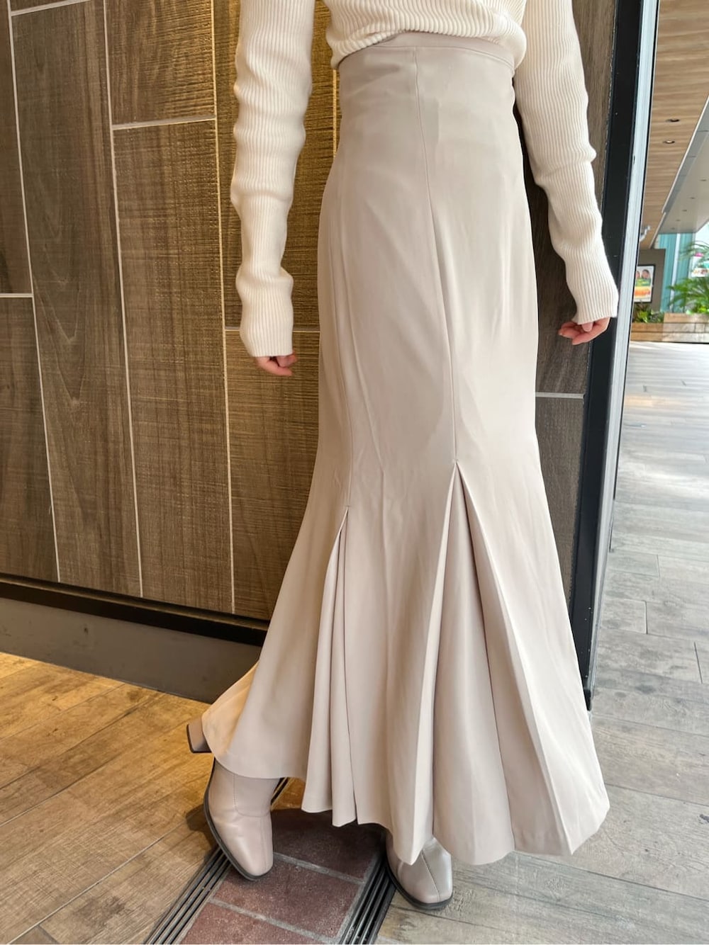 ベージュ系のブーツ、ベージュ系のスカート、ホワイト系のニット/セーターを着用したレディースの秋コーディネートの10枚目の写真