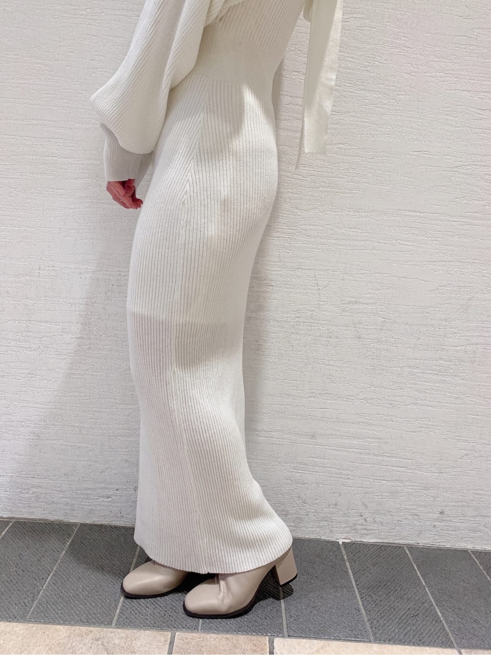 グレー系のブルゾン、ベージュ系のブーツ、ホワイト系のワンピースを着用したレディースの秋コーディネートの4枚目の写真