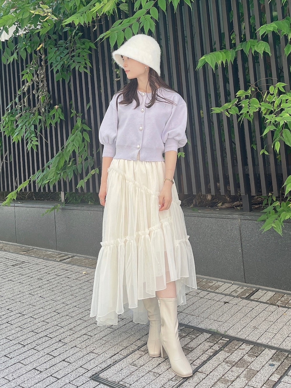 パープル系のカーディガン/ボレロ、ホワイト系のスカート、ホワイト系のブーツを着用したレディースの夏コーディネートの2枚目の写真